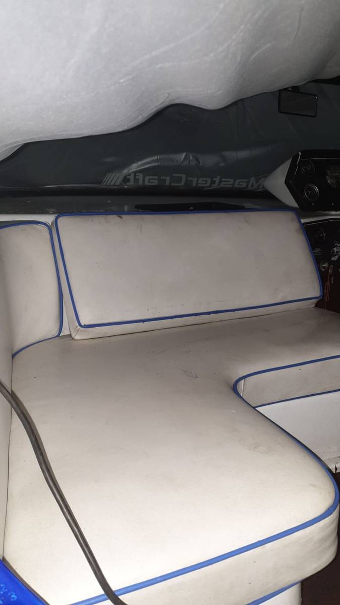 Worn MasterCraft cockpit bench seating in dirty white vinyl with blue piping