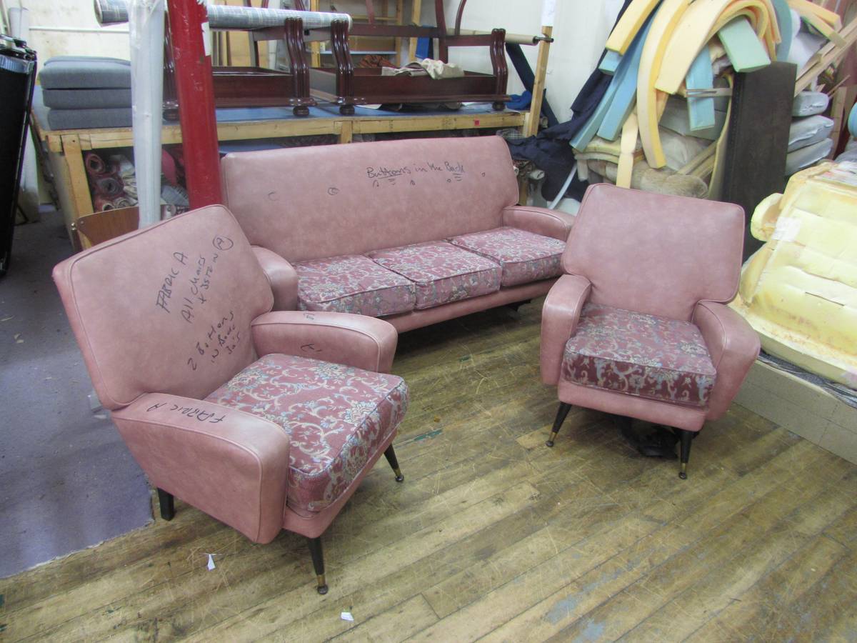 Mid-century suite in worn pink fabric in workshop before reupholstery