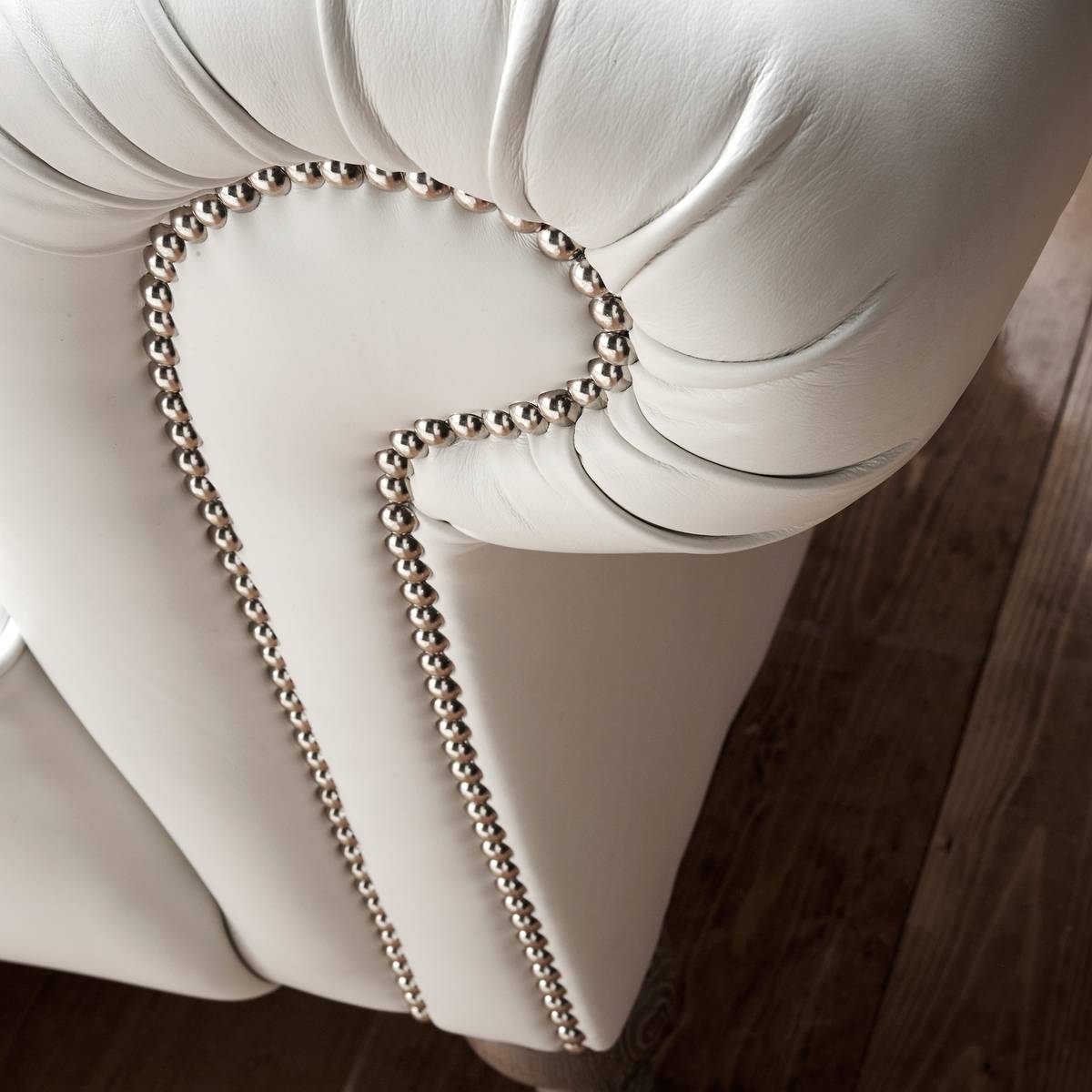 Scrolled arm with chrome nailhead studding